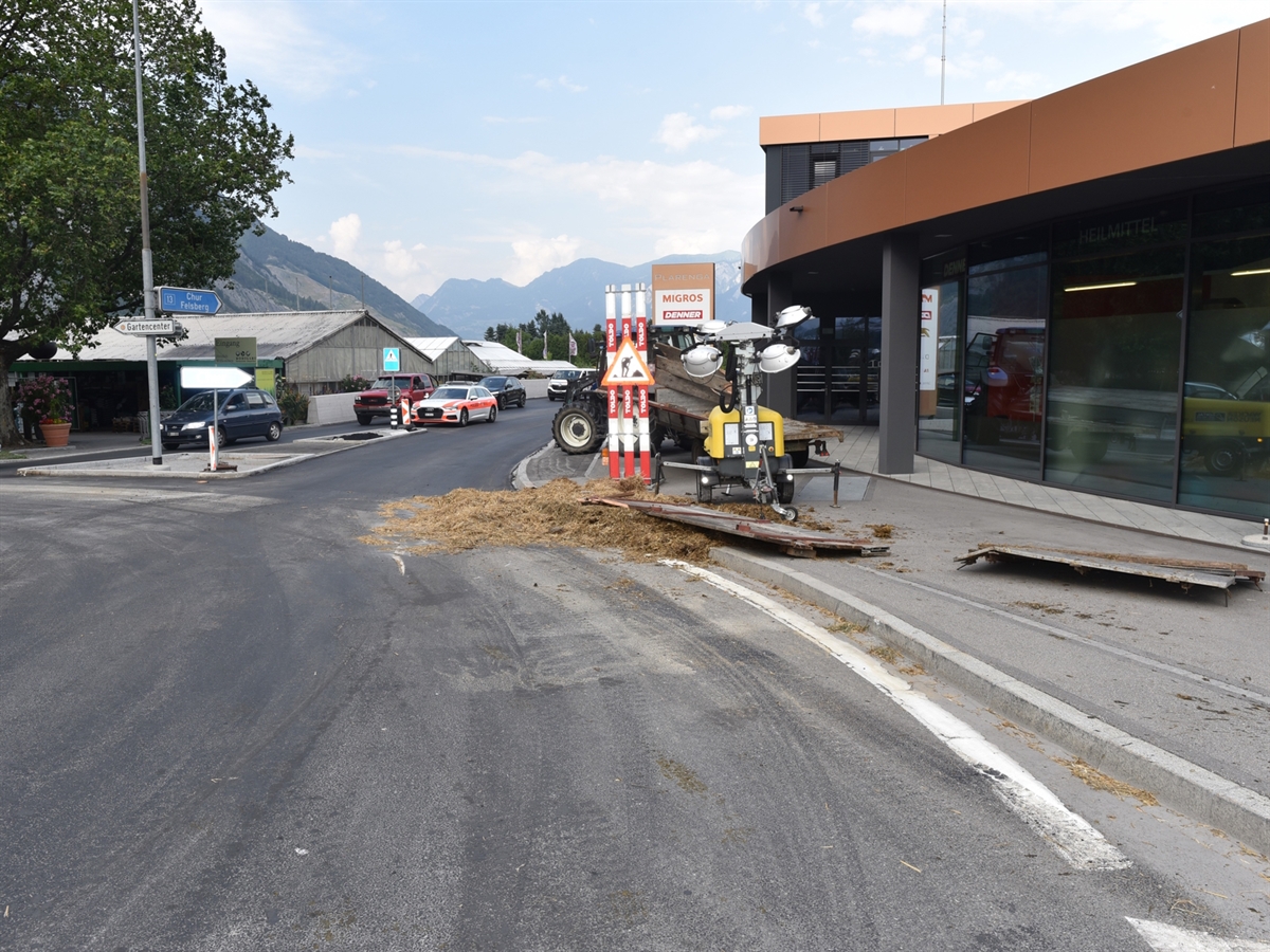 Bei der Ausfahrt aus dem Kreisel in Richtung Chur liegt viel Stroh. Auf dem Trottoir vor dem Geschäftsgebäude des Plarenga-Centers liegen Teile bzw. Seitenwände des Viehtransportanhängers. Hinter einem Baustellensignal steht der Traktor.