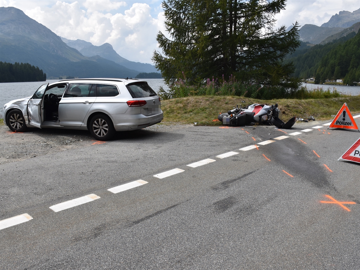 Das Auto auf dem Ausstellplatz. Dahinter das am Boden liegende Motorrad. Im Hintergrund der Silser See