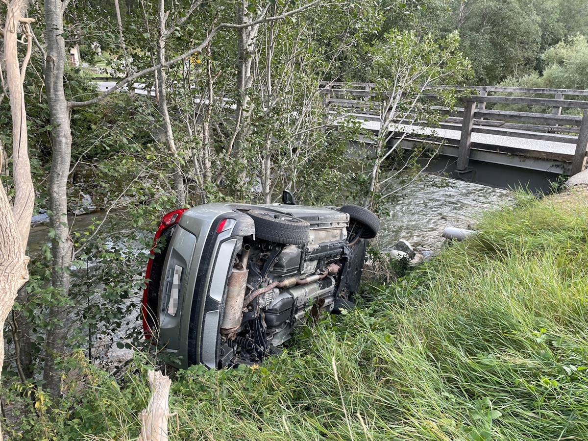 Das auf der linken Seite in der abfallenden Böschung liegende Auto. Unterhalb davon der Fluss Albula.