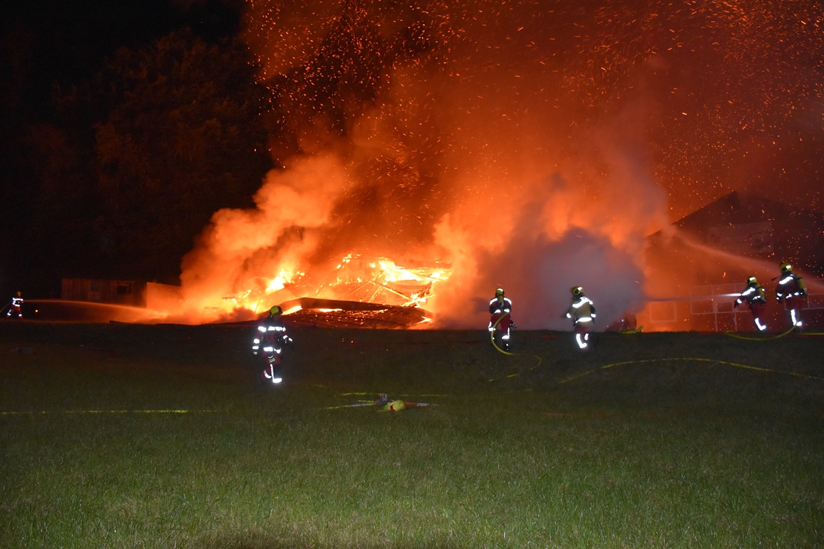 Flammen in der Nacht, Feuerwehrleute mit Schläuchen