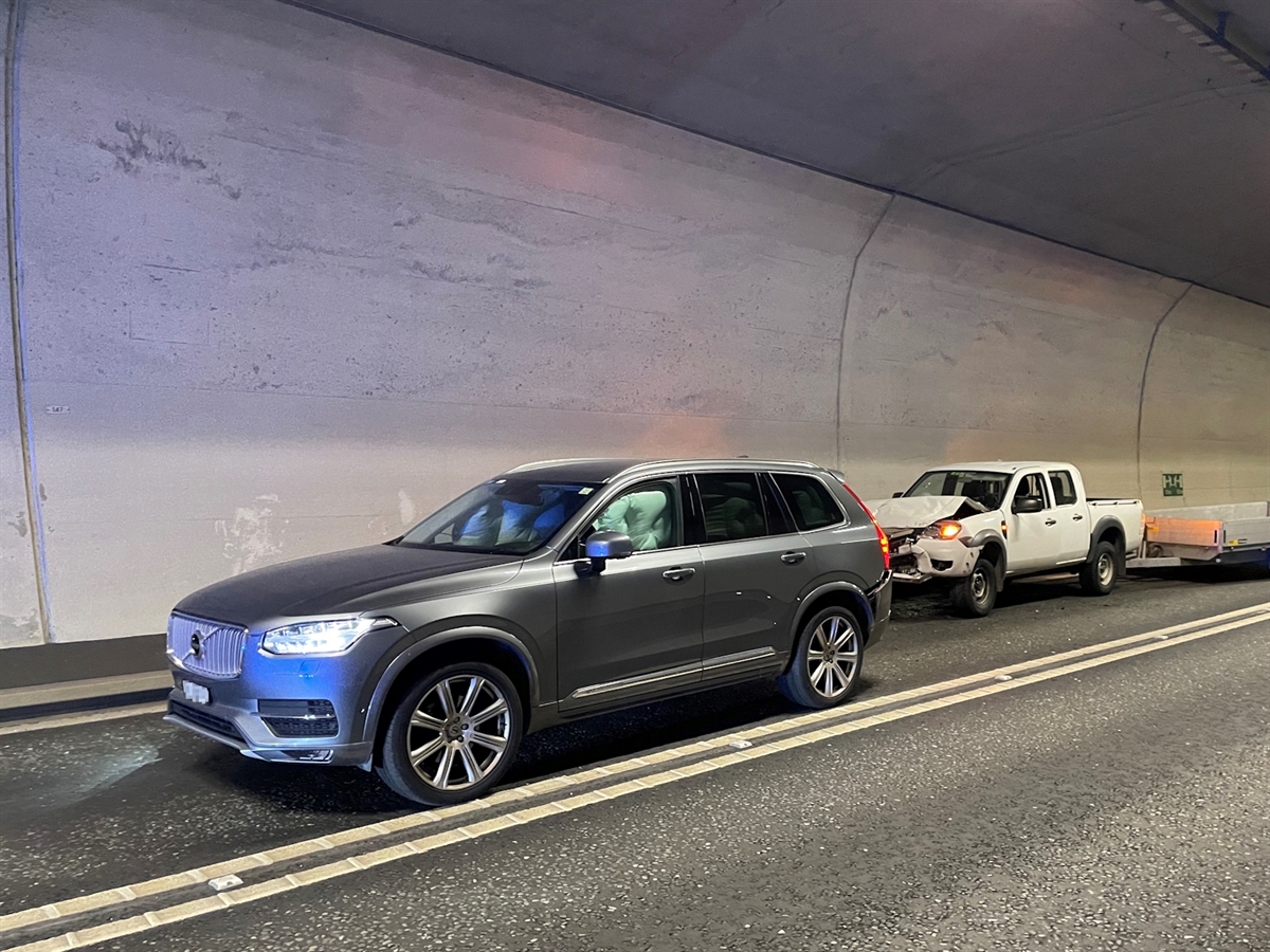 Links von schräg vorne ein Auto, die Airbags sind ausgelöst. Rechts dahinter der Lieferwagen mit beschädigter Front. Dahinter der Anhänger.