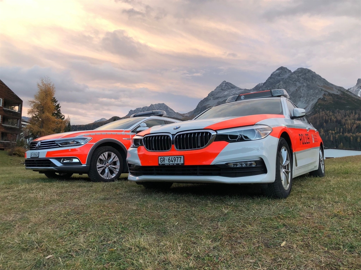 zwei Patrouillenautos der Kantonspolizei Graubünden vor traumhafter Bergkulisse